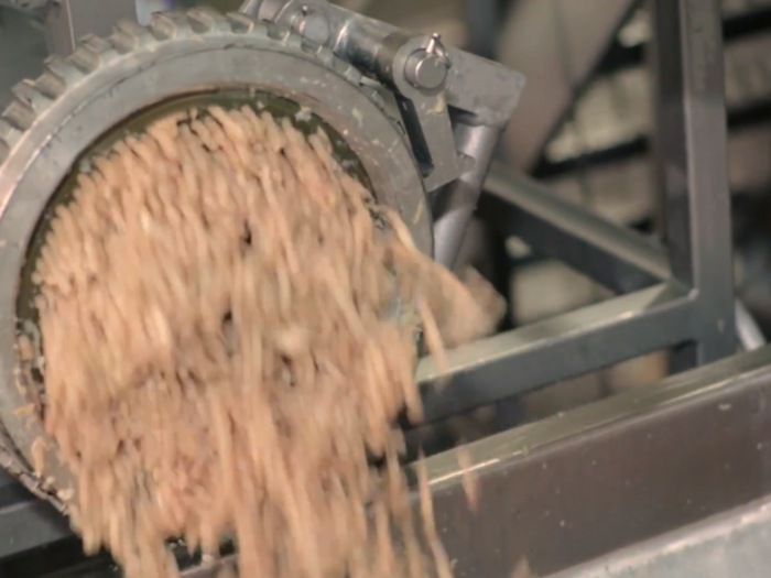 The mashed-up meat pours out of the grinder and straight into the blender.