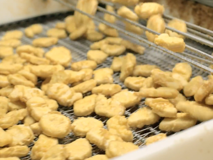 The nuggets come out of the fryer looking ready to eat, but they have only been partially cooked.