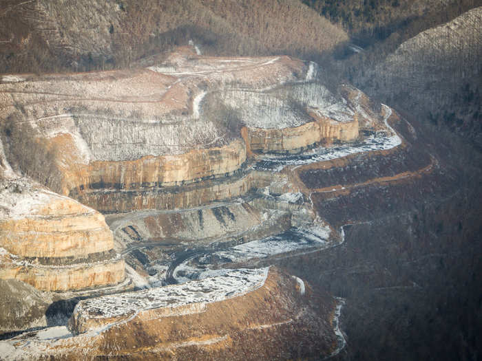 Under the powerful internal explosion the mountain cleaves apart. Up to 1,000 feet of mountaintop will be removed to expose the coal.