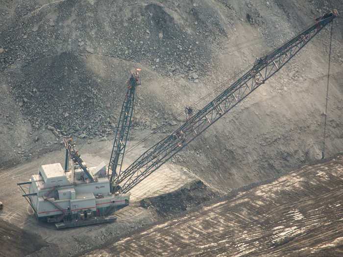 Then the coal is excavated, often using mammoth machines called drag lines. The boom is hundreds of feet long and its bucket holds space enough to fit about 26 full-size American sedans.