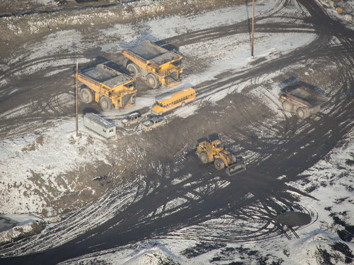 Loaded into the gargantuan Caterpillar 797s that run about $5 million each and weigh, fully loaded, greater than 1.3 million pounds apiece. Below is a full-size school bus sitting in front of two 797s.