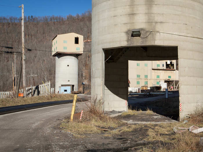 Trucks or train cars pull into the silo and accept their load, one after the other.