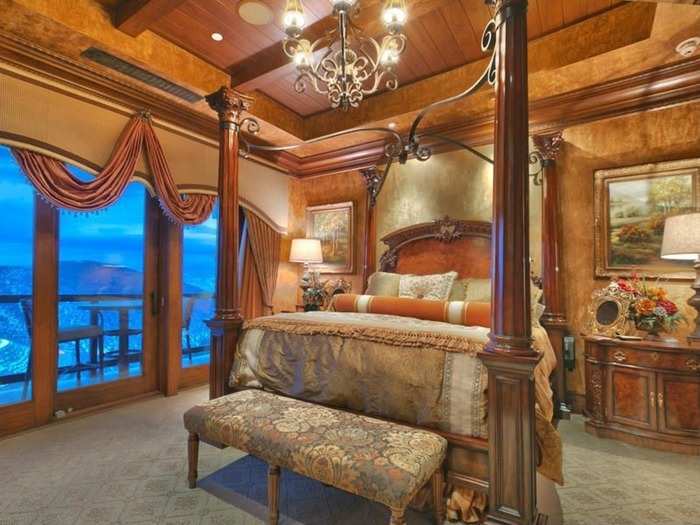 Here is the master bedroom with four-poster bed, porch, and chandelier.