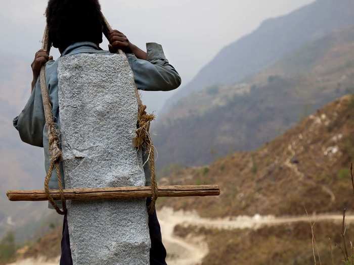 These Nepalese children in the Himalayas lug slabs of slate heavier than themselves down the mountain, while their parents break stones in the quarry.