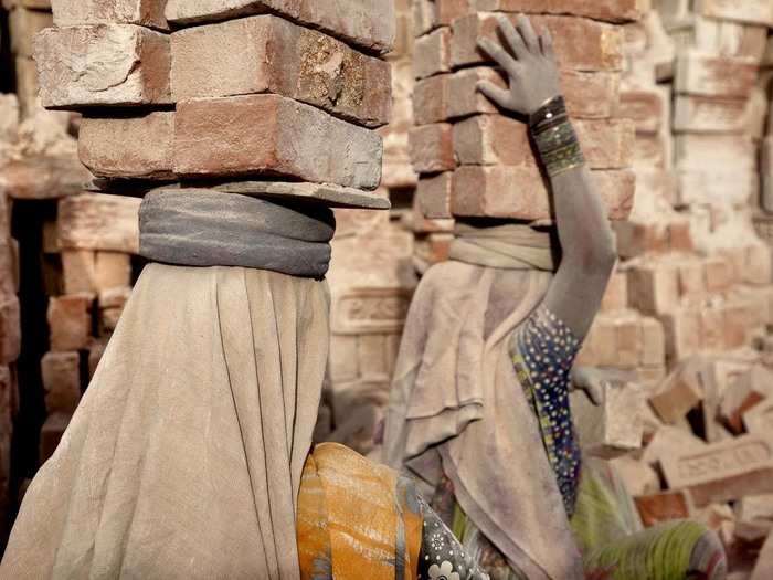 At the brick kiln, workers carry 18-bricks at a time in 130-degree heat to waiting trucks.