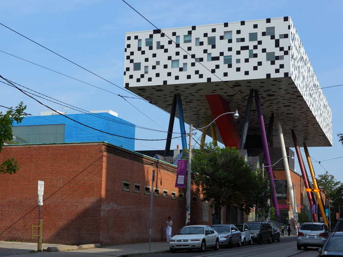 The Sharp Centre for Design at the Ontario College of Art and Design is hoisted 30 feet off the ground and supported by primary-colored stilts. The rectangular floating building holds two stories of studio and teaching space and is connected to the existing facility beneath it via an elevator and staircase.