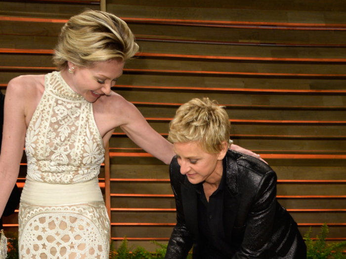 Show host Ellen DeGeneres switched into sneakers to help wife Portia De Rossi with her Naeem Khan gown.