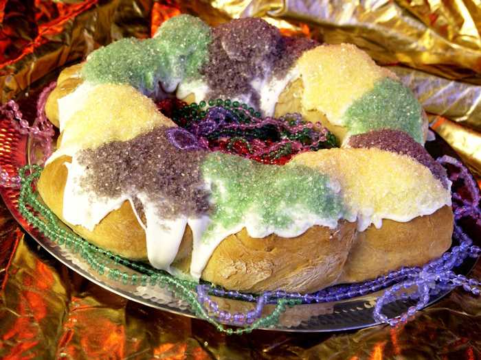 King Cake: A ring of brioche dough (usually braided) that is streaked with cinnamon topped with green, gold, and purple sugar. Traditionally eaten for Mardi Gras.