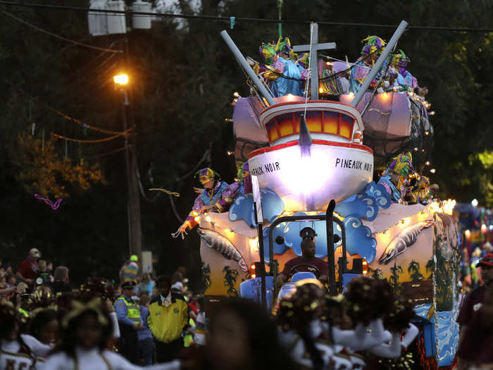 The Krewe of Bacchus Mardi Gras parade throws beads from their float. The cross on the bow is a nod to the Lent season that follows the carnival.