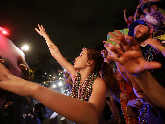 Parade-goers try to catch beads from the Krewe of Bacchus Mardi Gras parade on Napoleon Ave.