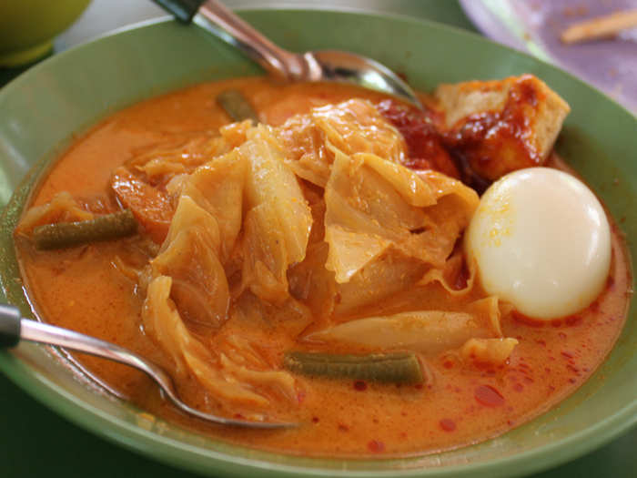 Lontong is a Malay dish that consists of a spongy rice cake cut into strips and cooked in a rich curry with vegetables and egg.