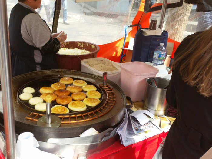 This stand had sweet cakes frying on a big pan.