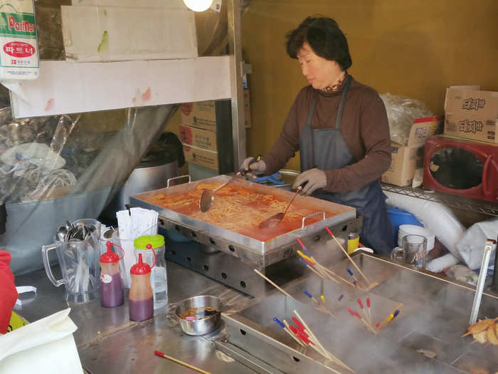 This woman was making noodles in a spicy red sauce.