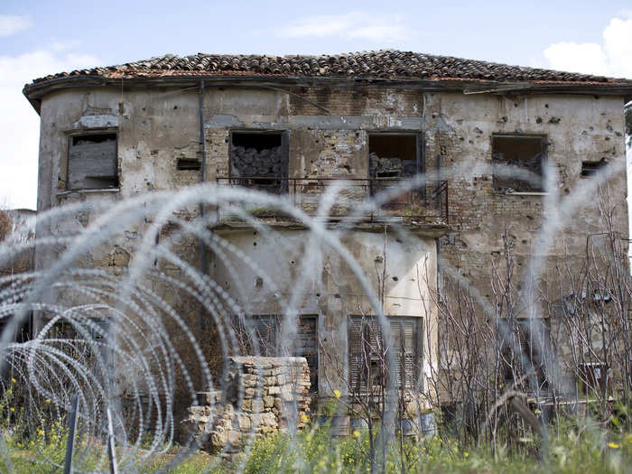 Former homes also stand empty, surrounded by barbed wire.