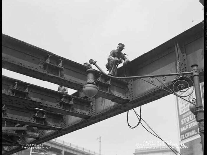 From Division Street, looking west, this worker demolishes the 2nd Ave El. train, August 11, 1942.