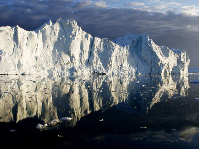Icebergs are reflected in the calm waters at the mouth of the Jakobshavn ice fjord on the west coast of Greenland.