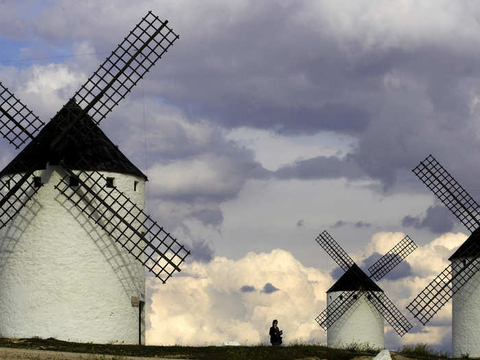 Tourists visit the famous ancient windmills in central Spain.