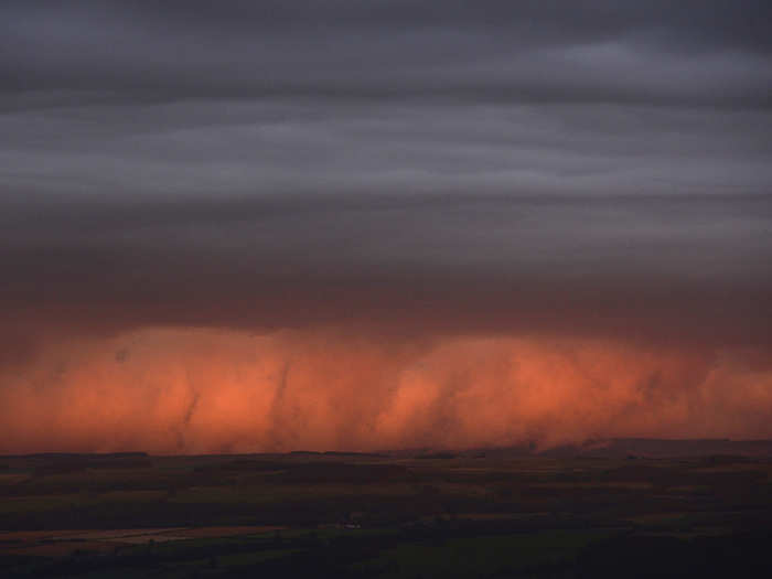 Rain clouds are lit by the setting sun in northern England.