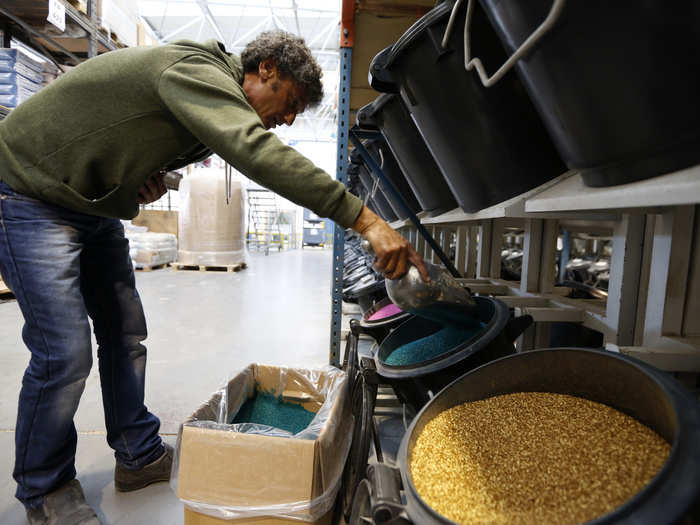 Employees load different colors into the machine.