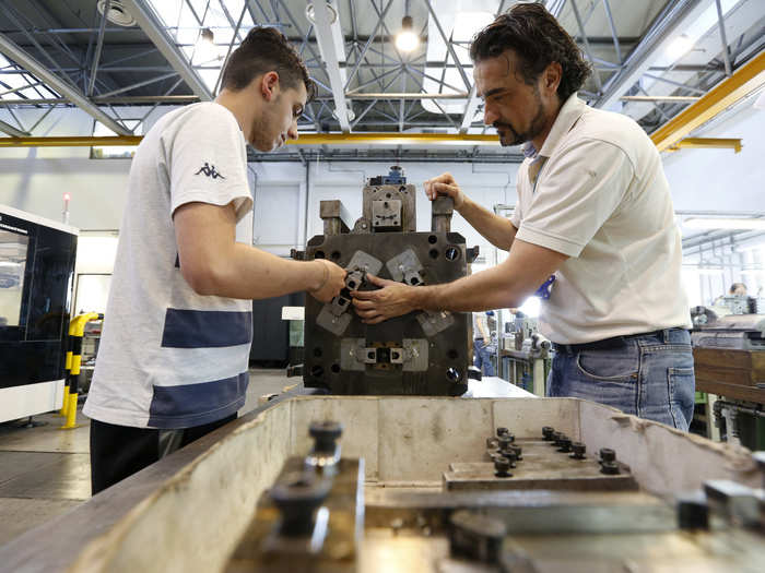 The supervisors make sure the molding machine is ready to go.