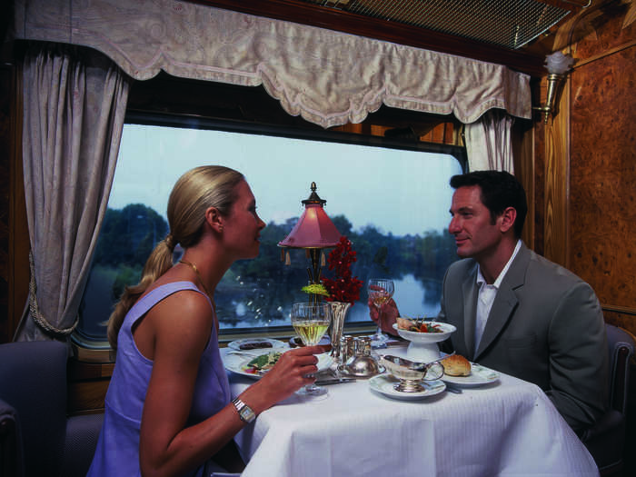 The train features two dining cars, a library car, a saloon car, and two bar cars, one of which has a large open-air observation deck.