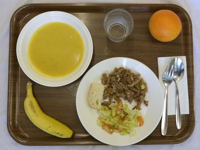 BARCELONA, SPAIN: This lunch is composed of cream of vegetable soup, pan-fried breast of veal with salad, a piece of bread, an orange or banana and water.