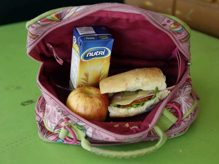 QUITO, ECUADOR: This packed lunch consists of a ham, cheese, tomato and lettuce sandwich, a boxed oatmeal drink, and an apple.