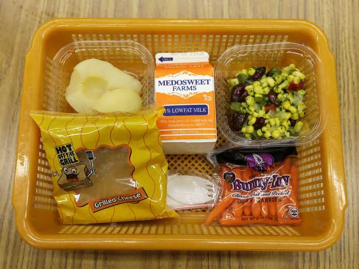 SEATTLE, US: A grilled cheese sandwich on whole grain bread is served with a southwestern-style corn salad, fresh carrots and either canned pears or apple sauce.