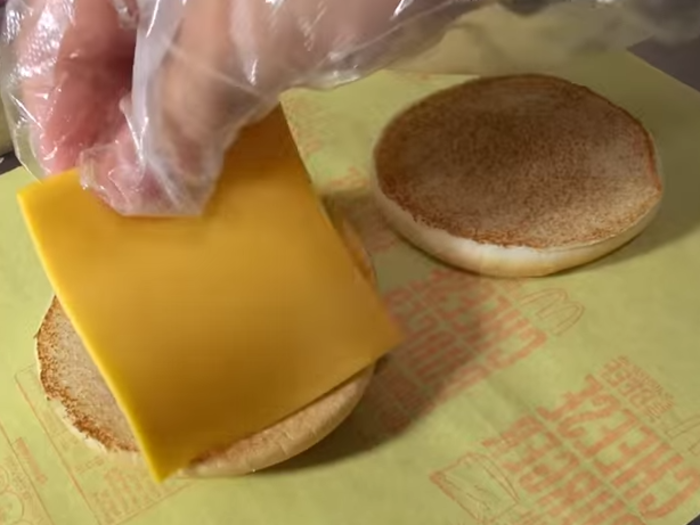 A slice of cheese is laid on top and the burger is nearly complete.