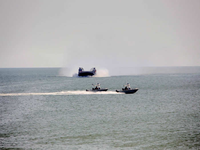 A couple small patrol craft speed past the LCA as it heads in.