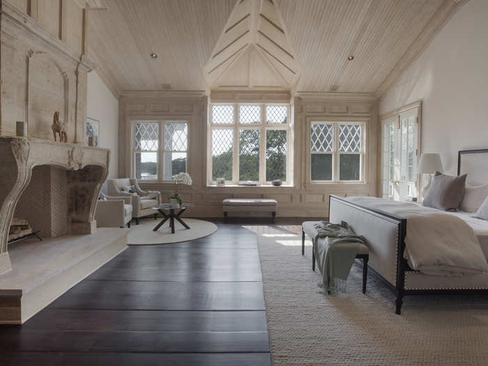 The master suite features a bedroom with an antique French stone fireplace, wainscoted ceiling, private porch, and a separate sitting room.