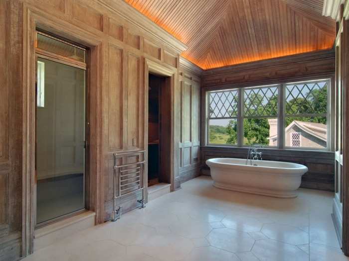 The master bath features a hand-carved limestone tub, a steam shower, sauna, and his-and-hers walk-in closets. The bathroom marble was selected in Verona, Italy, and the counters and tiles were carved from single blocks of stone by Italian craftsmen.