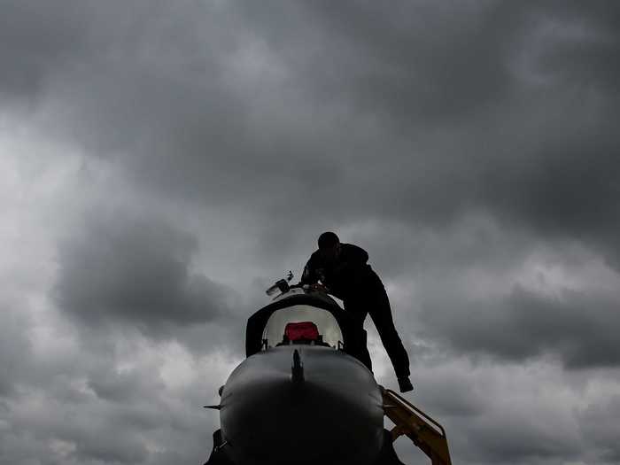 A Turkish Air Force F-16 underwent maintenance beneath a cloudy sky.