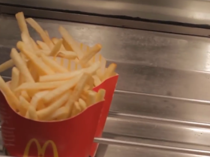 Once cooked, the fries are salted and put into the signature red containers.