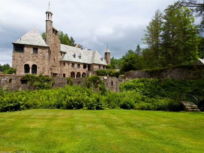 This castle has pointy towers and property with waterfalls and lakes.