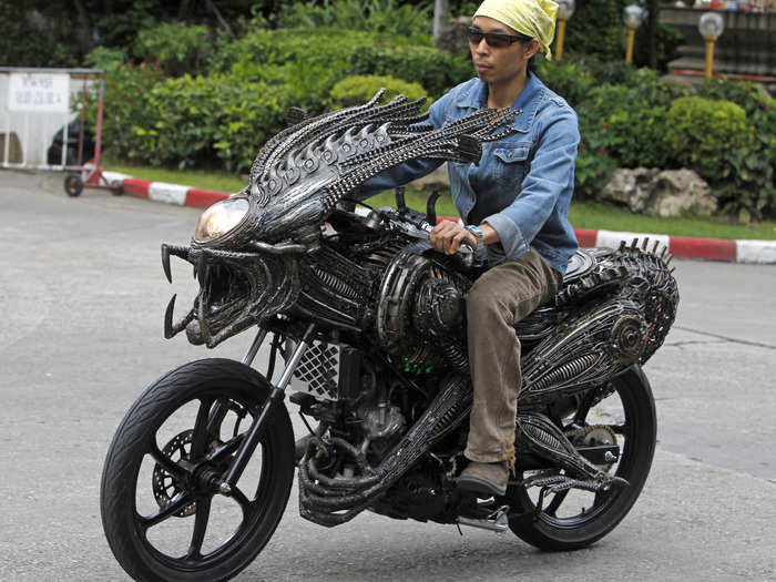 A worker in Bangkok rides on a (frighteningly realistic) insect-themed motorcycle.