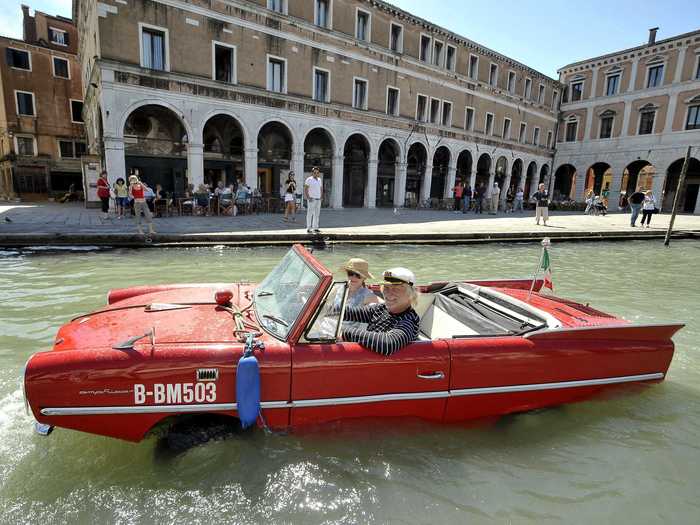 A member of the Amphicar Club of Berlin drives his amphibious car down the Grand Canal in Venice.