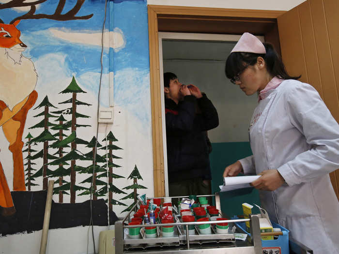 A nurse at Qide distributes medications to teens diagnosed with Internet addiction and depression.