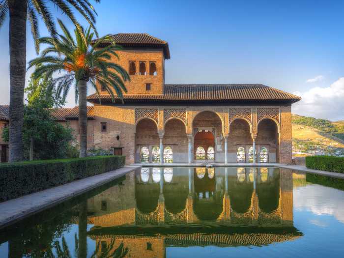 Marvel at the Moorish architecture and tranquil gardens of the Alhambra palace in Granada, Spain.