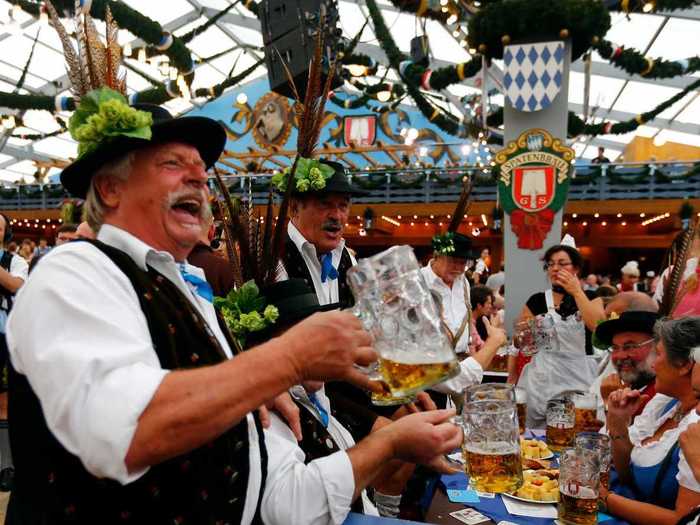 Drink a beer from a stein during Oktoberfest in Munich, Germany.
