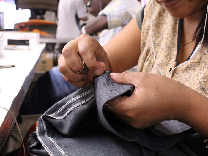 Every suit produced here is handmade, the culmination of 108 different operations done over the course of 16 labor hours. One person hand-sews the button holes, while another stitches the lining into the jacket sleeves.