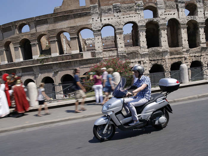 But Achilli is sure to make the most of his downtime. He rides a scooter past the Colosseum in Rome.