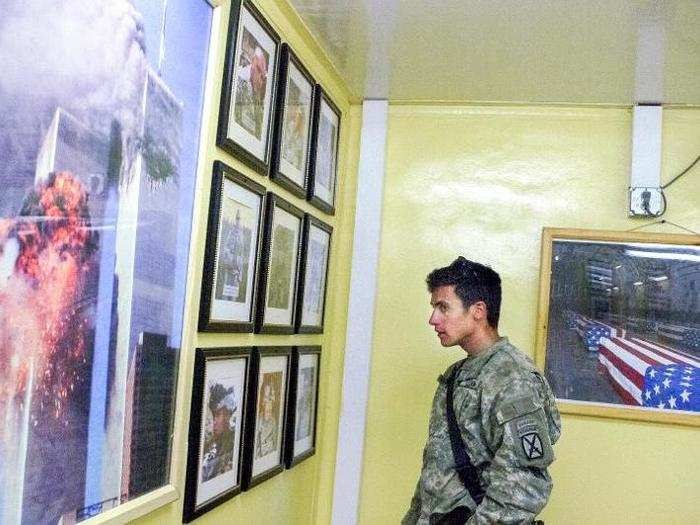 Lieutenant Erik Malmstrom looks at photos of three fallen soldiers from his brigade. His brigade lost more men than any single unit in Afghanistan. "To have a hope of succeeding [in Afghanistan] you have to be part warrior, part anthropologist, part diplomat, part development worker," Malmstrom told Van Agtmael.