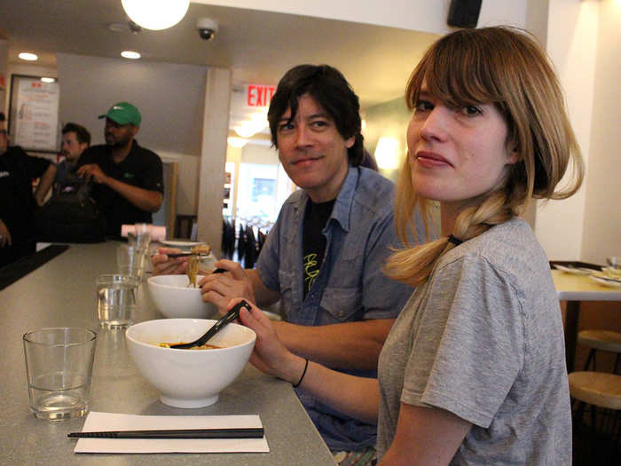 A couple diners nosh on ramen bowls at the counter. It