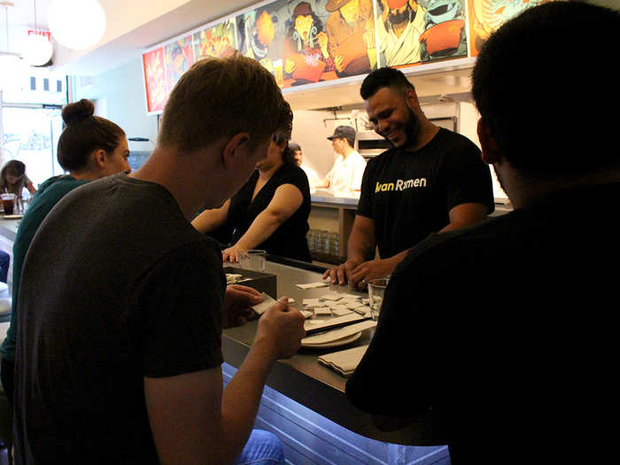 Dinner hour quickly approaches and the staff resumes prep. Waiters fold napkins into little squares, which will be used to wipe down the rims of ramen bowls before they exit the kitchen.