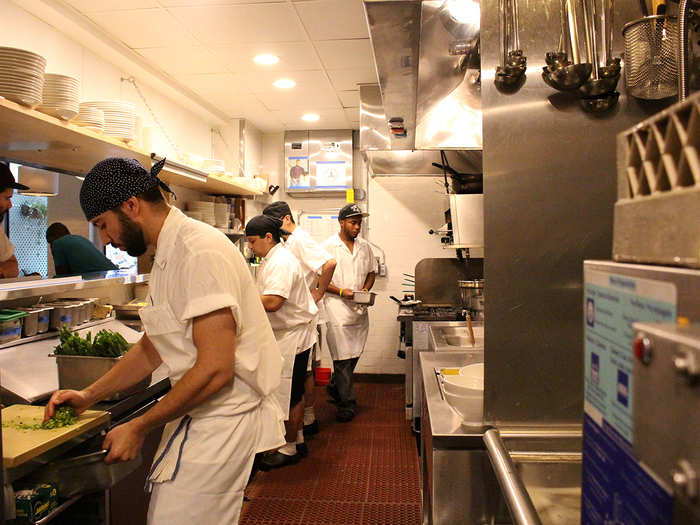 Back in the kitchen, the line cooks are busy dicing scallions, slicing hard-boiled eggs, and readying their work stations.