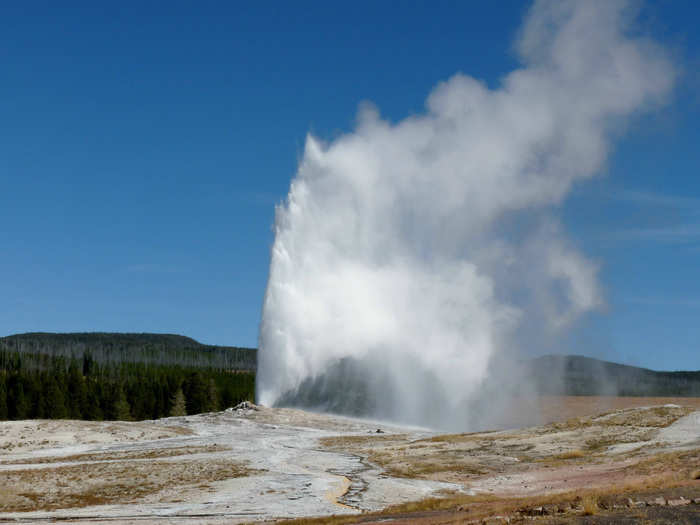 Wait for Old Faithful to erupt at Yellowstone National Park.