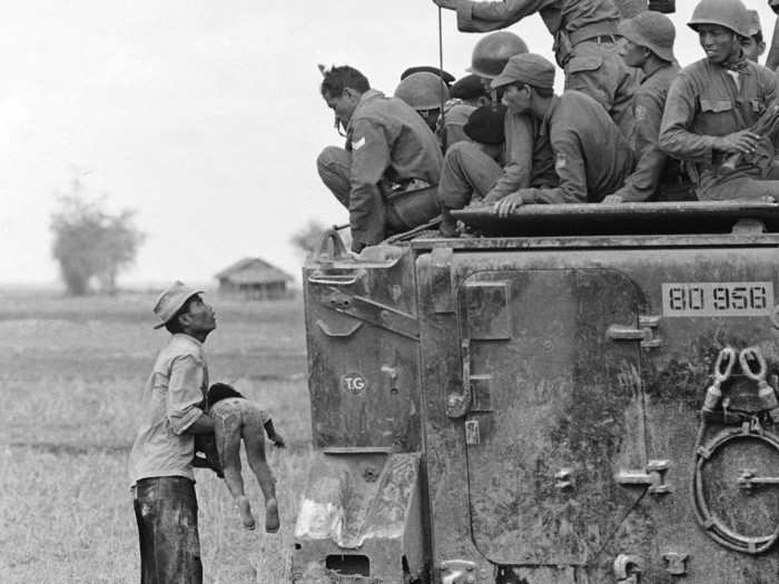 This photo, taken by Horst Faas, shows a father as he holds the body of his child as South Vietnamese Army Rangers look down from their armored vehicle March 19, 1964.  The child was killed as government forces pursued guerrillas into a village near the Cambodian border. It won Faas the Pulitzer Prize for Photography in 1965.