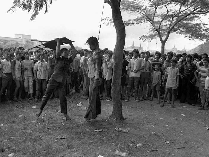 This photo, taken by Neal Ulevich in 1976, shows a member of a Thai political faction striking at the lifeless body of a hanged student outside Thammasat University in Bangkok. Police stormed the university after students demanded expulsion of a former military ruler and barricaded themselves in the school. The picture won the Pulitzer Prize in 1977.