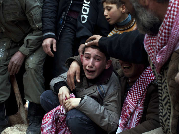 A boy mourns during a funeral for his father, Abdulaziz Abu Ahmed Khrer, who was killed by a Syrian army sniper in in Idlib, northern Syria. This photo by Rodrigo Abd was part of a larger portfolio of images from Syria that won a Pulitzer Prize in 2012.